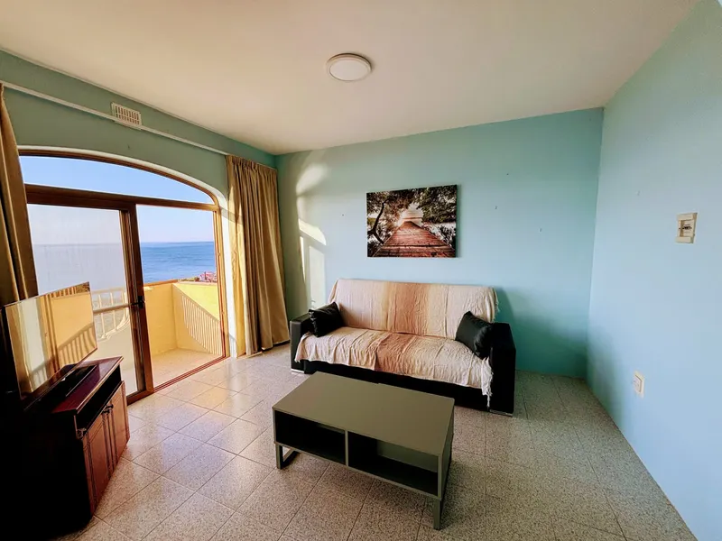 A SeaView Sunsets apartman nappalija nagy erkélyajtóval és tengerre néző kilátással