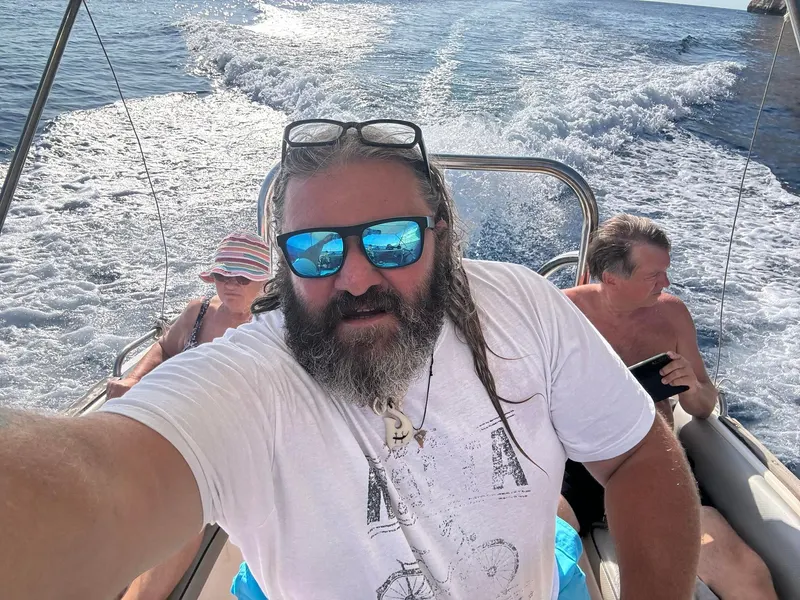 George a hajó kormányánál, mögötte a Vendégek, úton a nyílt tengeren