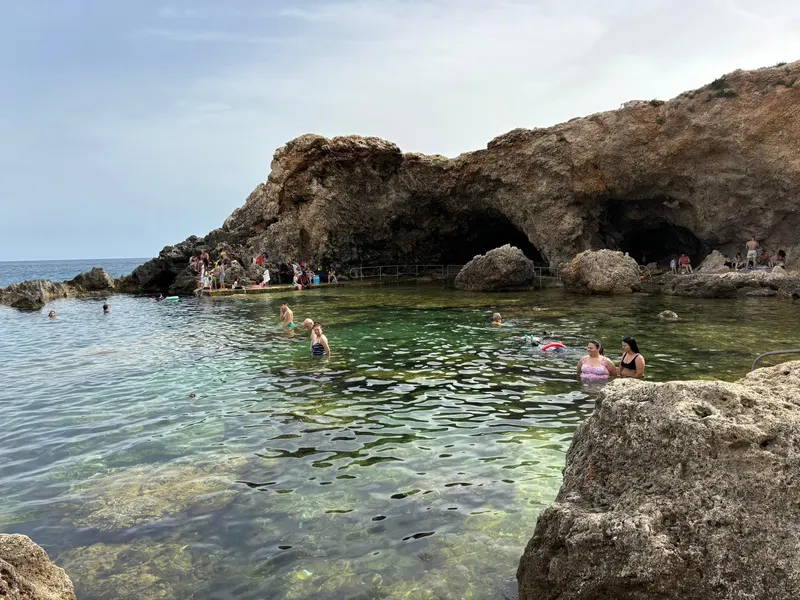 Fürdőzők a sziklák közé zárt, kristálytiszta Għar Lapsi-öbölben